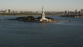 4K aerial stock footage Tilting up from New York Harbor, revealing Statue of Liberty, New York, sunrise Aerial Stock Footage | AX90_148