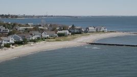 4K aerial stock footage of flying by a beach, breakwaters, and beachfront homes in Fairfield, Connecticut Aerial Stock Footage | AX91_116