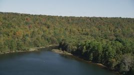 4K aerial stock footage of approaching forest on the shore of the lake in autumn, Lake Saltonstall, Connecticut Aerial Stock Footage | AX91_147