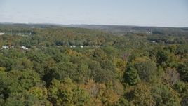 4K aerial stock footage of flying over forest, revealing town in autumn, East Haven, Connecticut Aerial Stock Footage | AX91_148