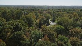 4K aerial stock footage of flying over lush forest, revealing homes in autumn, Guilford, Connecticut Aerial Stock Footage | AX91_170