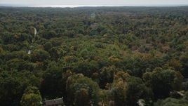 4K aerial stock footage flyby homes and forest, reveal road through forest in autumn, Guilford, Connecticut Aerial Stock Footage | AX91_177