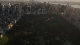 4K aerial stock footage Flying over Central Park, tilt to Midtown Manhattan, New York, sunset Aerial Stock Footage | AX93_024