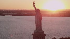 4K aerial stock footage Flying by the Statue of Liberty, New York Harbor, New York, New York, sunset Aerial Stock Footage | AX93_110