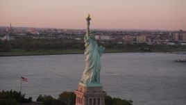 4K aerial stock footage Flying by Statue of Liberty, New York Harbor, reveal Ellis Island, New York, sunset Aerial Stock Footage | AX93_114