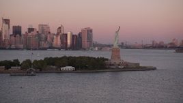 4K aerial stock footage Approaching the Statue of Liberty, Lower Manhattan skyline, New York, sunset Aerial Stock Footage | AX93_119