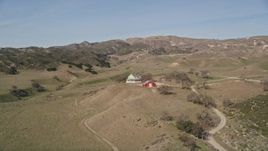 5K aerial stock footage of flying over a hill, revealing isolated ranch house and barn, Simi Valley, California Aerial Stock Footage | AXSF01_004