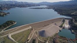 5K aerial stock footage of flying by the Bradbury Dam, tilt to wider view of Lake Cachuma, California Aerial Stock Footage | AXSF01_047
