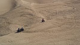 5K aerial stock footage of orbiting ATV riders on coastal sand dunes, Pismo Dunes, California Aerial Stock Footage | AXSF02_024