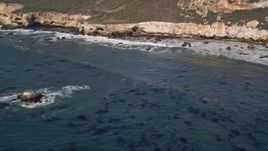 5K aerial stock footage of flying by waves rolling in toward coastal cliffs, San Luis Obispo, California Aerial Stock Footage | AXSF02_037
