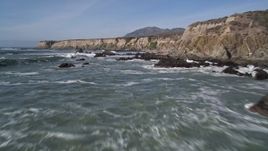 5K aerial stock footage of flying over waves rolling into rock formations, coastal cliffs, Avila Beach, California Aerial Stock Footage | AXSF02_049