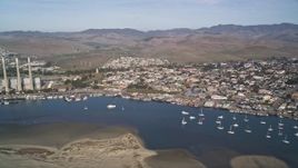 5K aerial stock footage of a beach, coastal homes by the harbor, pan to reveal Dynegy Power Plant, Morro Bay, California Aerial Stock Footage | AXSF03_007