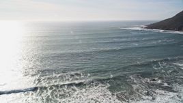 5K aerial stock footage video of flying over ocean waves, pan to reveal coastal hills, Cayucos, California Aerial Stock Footage | AXSF03_014
