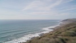 5K aerial stock footage of tilting from green hills to reveal the coastline, Cayucos, California Aerial Stock Footage | AXSF03_016