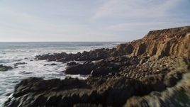 5K aerial stock footage of flying low over waves crashing into coastal cliffs, Harmony, California Aerial Stock Footage | AXSF03_019