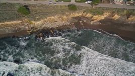5K aerial stock footage of flying by a beach as waves roll in, Cambria, California Aerial Stock Footage | AXSF03_030