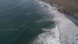 5K aerial stock footage of flying over waves rolling into the coast by Highway 1, San Simeon, California Aerial Stock Footage | AXSF03_038