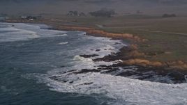 5K aerial stock footage pan across waves and coastline to reveal lonely oceanfront home, San Simeon, California Aerial Stock Footage | AXSF03_057