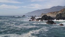 5K aerial stock footage of flying over rock formations and waves off the coast, San Simeon, California Aerial Stock Footage | AXSF03_059