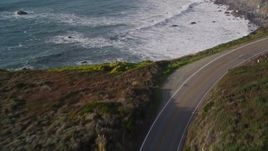 5K aerial stock footage of flying over Highway 1 coastal road, and tilt to ocean waves, Big Sur, California Aerial Stock Footage | AXSF03_079