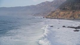 5K aerial stock footage of flying over tall waves, pan right revealing coastal cliffs, Big Sur, California Aerial Stock Footage | AXSF03_085