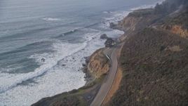 5K aerial stock footage of tilting from Highway 1 coastal road to cliffs to the coastline, reveal campground, Big Sur, California Aerial Stock Footage | AXSF03_087