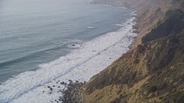 5K aerial stock footage pan to reveal waves rolling toward cliffs, Big Sur, California Aerial Stock Footage | AXSF03_089