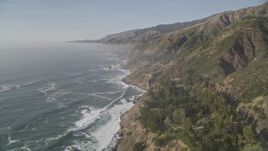 5K aerial stock footage fly over cliffs on the California coast with ocean waves rolling in, Big Sur, California Aerial Stock Footage | AXSF03_093