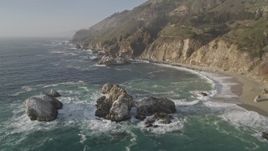 5K aerial stock footage tilt from rock formations in the ocean to reveal coastal cliffs, Big Sur, California Aerial Stock Footage | AXSF03_095