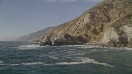 5K aerial stock footage of flying low over waves by coastal cliffs and rock formations, Big Sur, California Aerial Stock Footage | AXSF03_097