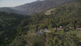 5K aerial stock footage of flying over Ventana Inn & Spa hotel, reveal highway through forest, Big Sur, California Aerial Stock Footage | AXSF03_102