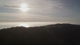 5K aerial stock footage of the sun high over the Pacific Ocean, seen from the hills, Big Sur, California Aerial Stock Footage | AXSF03_105