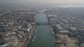5K aerial stock footage fly over the Oakland Estuary toward bridges and factories, Oakland, California Aerial Stock Footage | AXSF05_088