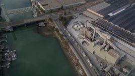 5K aerial stock footage of flying over estuary and warehouses, reveal factory, Fruitvale Bridge, Park Street Bridge, Oakland Estuary, California Aerial Stock Footage | AXSF06_002