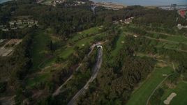 5K aerial stock footage fly over MacArthur Tunnel and The Presidio Golf Course, tilt to reveal Golden Gate Bridge, San Francisco, California Aerial Stock Footage | AXSF06_041