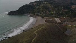 5K aerial stock footage of panning across hills to reveal Muir Beach and hillside homes, Marin County, California Aerial Stock Footage | AXSF06_050