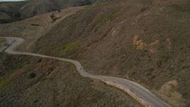 5K aerial stock footage of flying over coastal cliffs to reveal and follow Highway 1 at the base of mountains, Marin County, California Aerial Stock Footage | AXSF06_053
