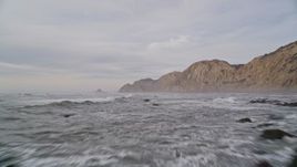 5K aerial stock footage of flying low over ocean and rocks near coastal cliffs, Bolinas, California Aerial Stock Footage | AXSF06_061