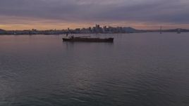 5K aerial stock footage fly over an oil tanker in San Francisco Bay, and tilt to the city's skyline in the distance at sunset, California Aerial Stock Footage | AXSF07_002