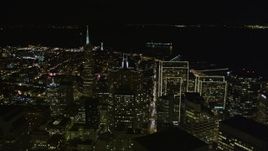5K aerial stock footage tilt from busy streets to reveal skyscrapers, Transamerica Pyramid, and Coit Tower,  Downtown San Francisco, California, night Aerial Stock Footage | AXSF07_023