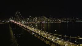 5K aerial stock footage approach heavy traffic on the upper deck of the Bay Bridge, Downtown San Francisco skyline in background, California, night Aerial Stock Footage | AXSF07_031