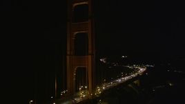 5K aerial stock footage of tilting from traffic on the Golden Gate Bridge to one of the towers and back, San Francisco, California, night Aerial Stock Footage | AXSF07_040