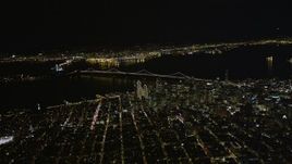 5K aerial stock footage of a high altitude view of Coit Tower, the Bay Bridge, and skyscrapers in Downtown San Francisco, California, night Aerial Stock Footage | AXSF07_073