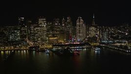 5K aerial stock footage of flying away from the Ferry Building to reveal Downtown San Francisco skyscrapers at night, California Aerial Stock Footage | AXSF07_083