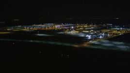5K aerial stock footage reverse view of Oakland International Airport, Oakland, California, night Aerial Stock Footage | AXSF07_102