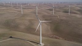 5K aerial stock footage tilt from small hills, reveal Shiloh Wind Power Plant windmills, Montezuma Hills, California Aerial Stock Footage | AXSF08_065