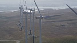 5K aerial stock footage orbit top of windmill, reveal and flyby row of windmills, Shiloh Wind Power Plant, California Aerial Stock Footage | AXSF08_074