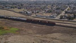 5K aerial stock footage of flying by a train traveling past residential neighborhoods, Pittsburg, California Aerial Stock Footage | AXSF08_088