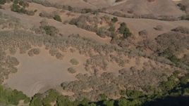 5K aerial stock footage of a reverse view of brown hills and green trees at Briones Regional Park, Martinez, California Aerial Stock Footage | AXSF09_007