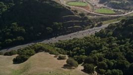 5K aerial stock footage of Highway 24 freeway through hills, tilt to soccer fields, Orinda, California Aerial Stock Footage | AXSF09_010